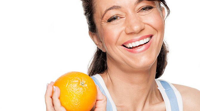 Lachende Vrouw Met Sinaasappel In de Hand