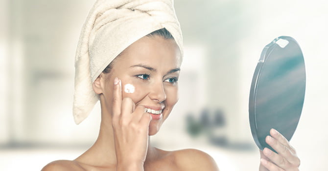 Vrouw Met Spiegel Die Creme Smeert